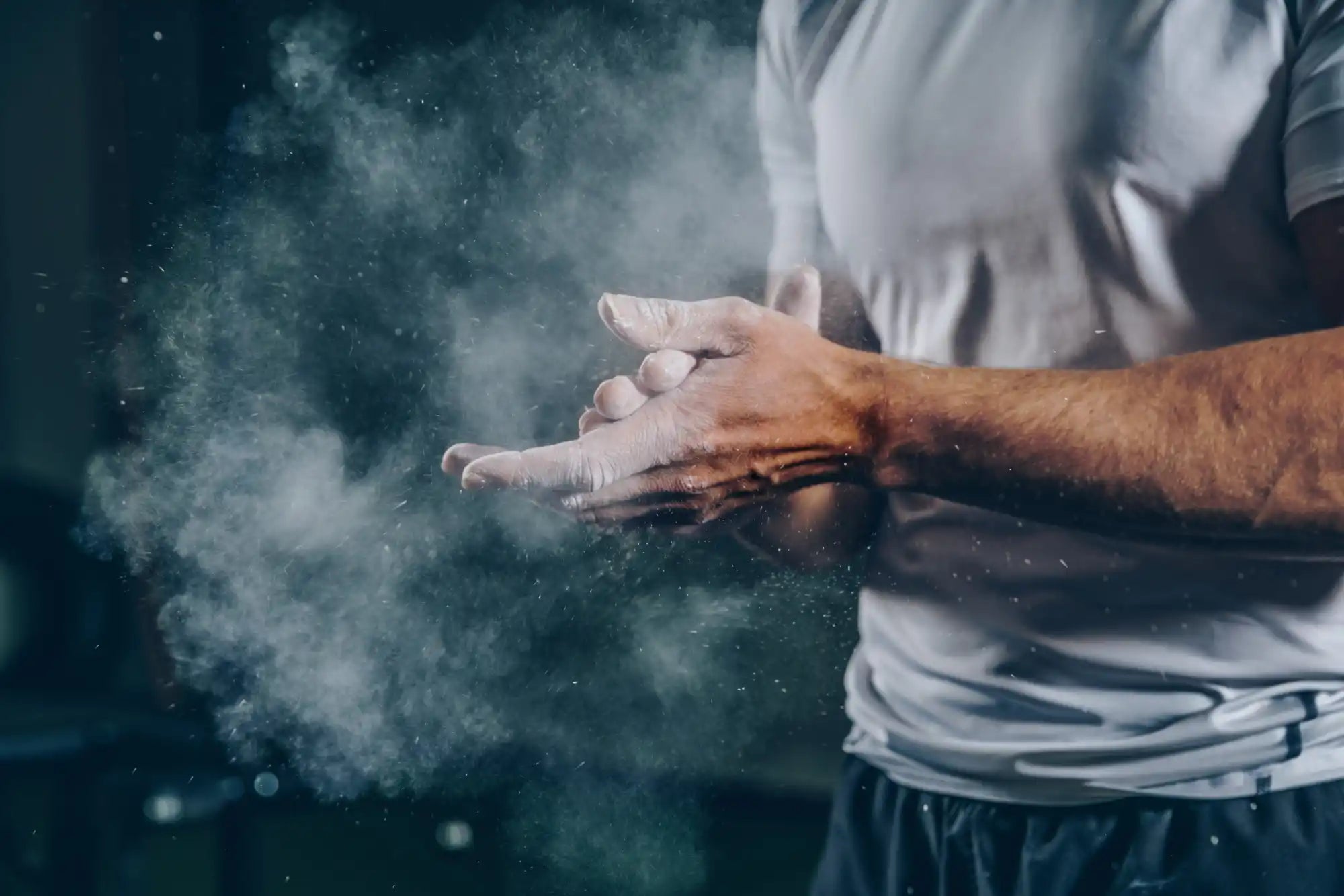 Hands clapping with white powder or chalk dust creating a cloud.